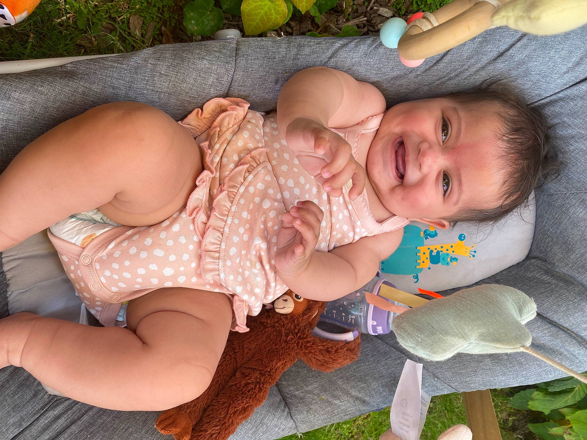 Jade participe au concours pour gagner de l'argent avec cette photo : baby, baby_toddler_clothing, cheek, eye, finger, grass, green, happy, human_body, joy, lap, mouth, organ, person, pink, plant, skin, smile, thigh, toddler