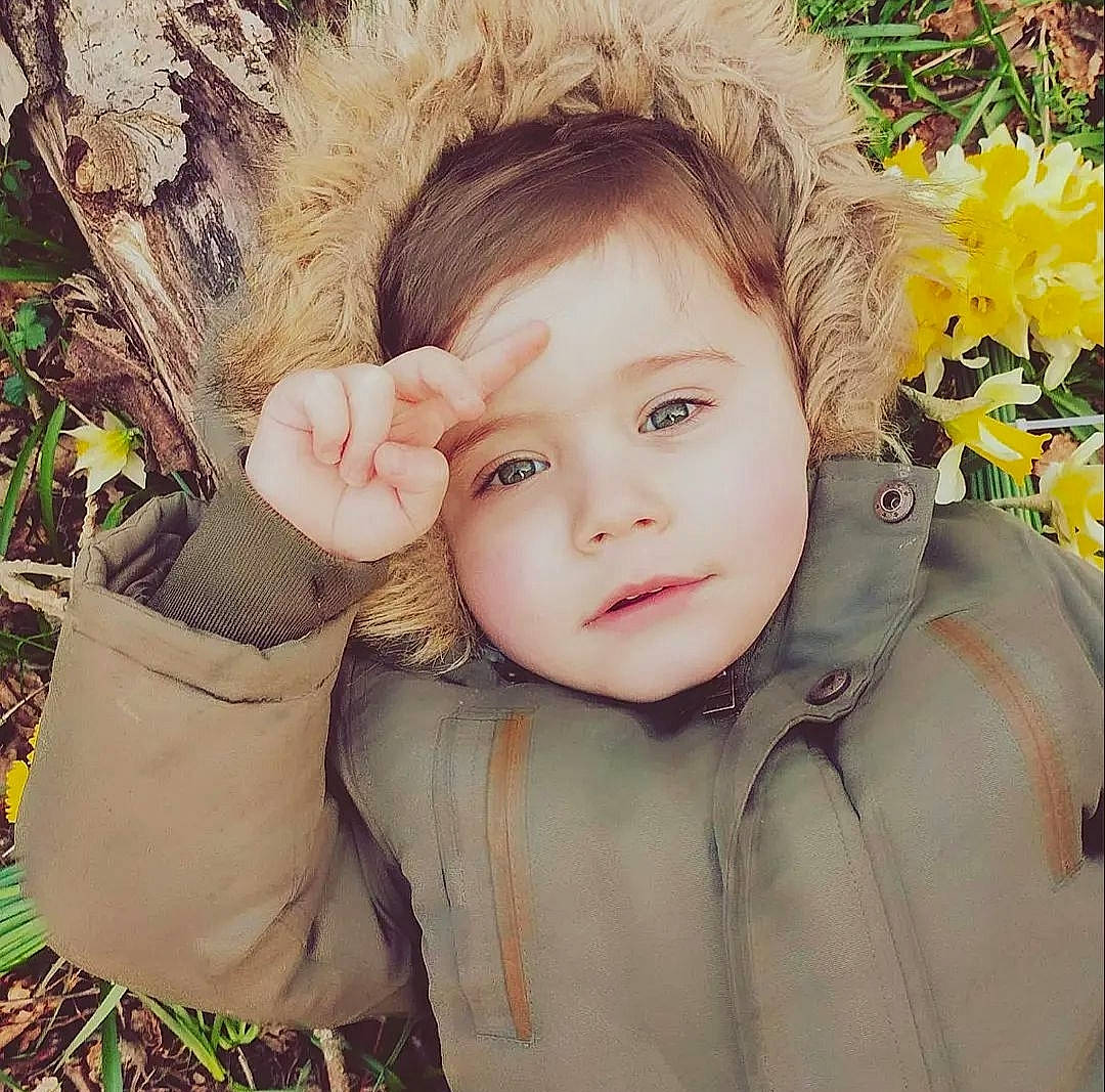 Esteban participe au concours pour gagner de l'argent avec cette photo : cool, eye, eyelash, finger, gesture, grass, hand, happy, head, iris, leaf, lip, neck, outerwear, people_in_nature, person, plant, skin, sleeve, toddler