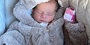 Lola is registered to the contest to win money with this photo: baby, sleeping, stroller, fur_clothing, hood, cozy, infant, blanket, cute, child, soft_texture, peaceful, warm, bundle, portrait, indoor, clothing, newborn, rest, toddler