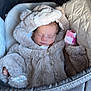 baby, sleeping, stroller, fur_clothing, hood, cozy, infant, blanket, cute, child, soft_texture, peaceful, warm, bundle, portrait, indoor, clothing, newborn, rest, toddler