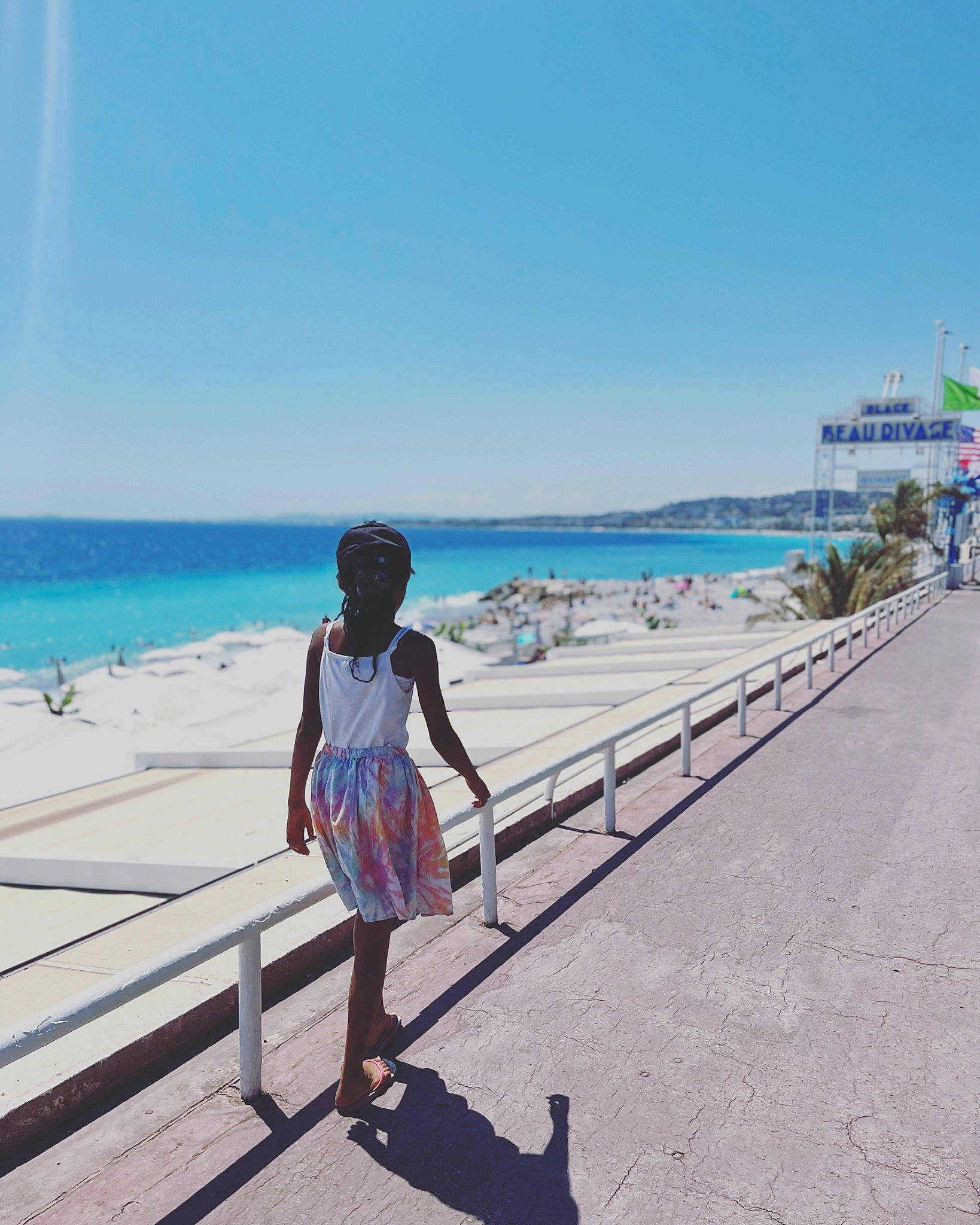 Liyah participe au concours pour gagner de l'argent avec cette photo : azure, beach, boardwalk, body_of_water, electric_blue, fun, holiday, horizon, human_leg, leisure, ocean, pedestrian, people_in_nature, person, sand, shore, sky, travel, tree, under_exposed