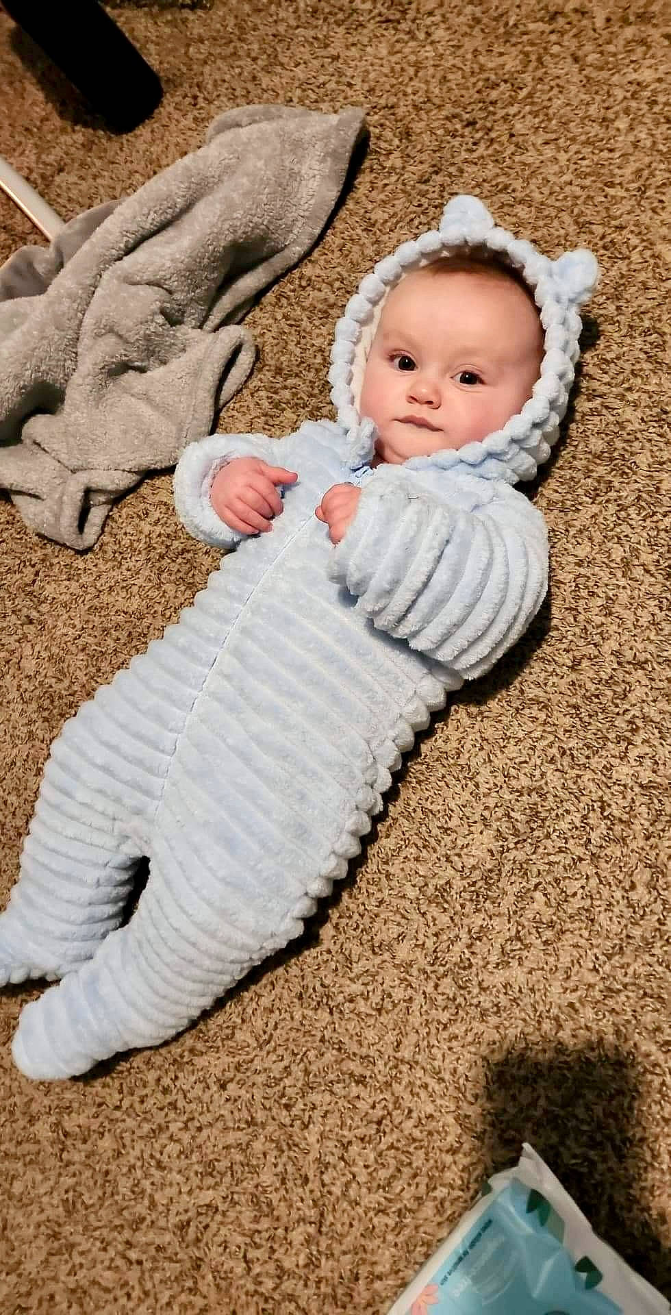 Blair is registered to the contest to win money with this photo: baby, baby_toddler_clothing, cheek, child, comfort, flooring, fur, grass, happy, human_body, linens, pattern, people_in_nature, person, sitting, skin, sleeve, toddler, wood, wool