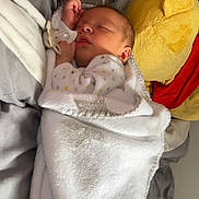 Lyam a rejoint le concours — aidez-le/la à gagner de superbes lots ! baby, bed, blanket, child, clothing, comfort, cushion, cute, face, furniture, indoors, infant, pacifier, plush_toy, portrait, rest, sleeping, soft, toddler, toy