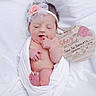 newborn, baby, infant, headband, flower, white_cloth, wrapped, sleeping, plaque, birth_announcement, soft_blanket, peaceful, cute, small, pink_flower, skin, human, portrait, lying_down, indoors