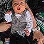 Elijah is registered to the contest to win money with this photo: baby, child, person, infant, clothing, hat, vest, hand, watch, tattoo, blanket, sitting, expression, indoor, portrait, cute, curious, holding, striped_blanket, black_pants