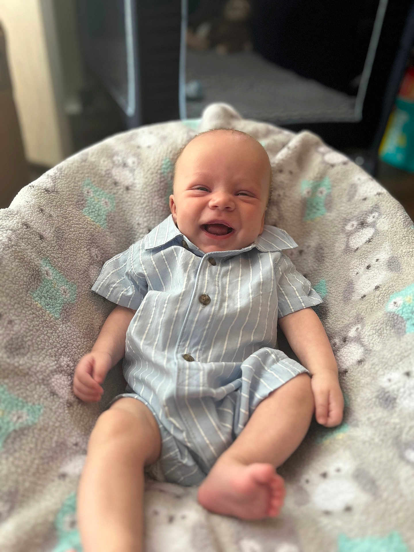 Jace is registered to the contest to win money with this photo: baby, infant, smiling, romper, striped_clothing, blanket, patterned_blanket, owl_pattern, soft_texture, indoor, happy, cute, child, person, portrait, sitting, comfort, cozy, skin, head