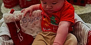 Bryce joined the competition — help win amazing prizes! baby, beige_pants, blanket, child, christmas, cozy, cute, decorations, festive, gift_box, holiday, indoor, knit_hat, present, red_bow, red_shirt, reindeer_ears, sitting, stocking, toy