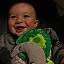Bryce is registered to the contest to win money with this photo: baby, blanket, car_seat, child, closeup, clothing, cozy, cute, face, frog, green_leaf, happy, indoor, infant, moon_toy, plush_toy, portrait, seat, smiling, soft_lighting