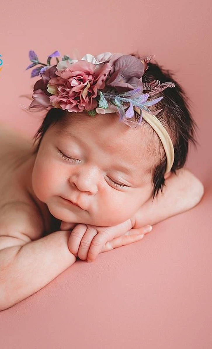 Colby joined the competition — help win amazing prizes! baby, baby_toddler_clothing, chin, close_up, eye, eyebrow, eyelash, facial_expression, finger, grass, hand, happy, headband, headpiece, iris, lip, person, petal, pink, skin