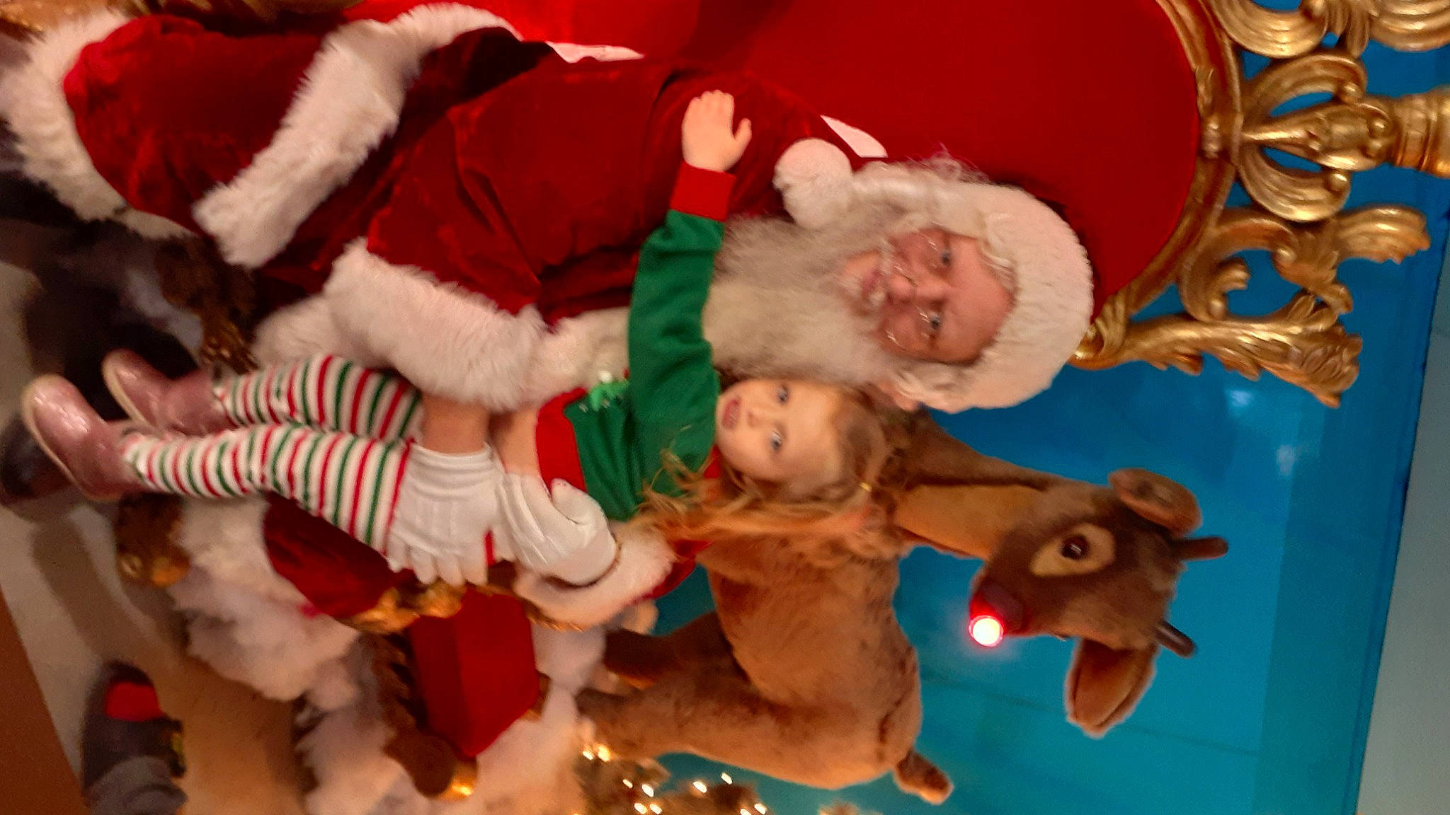 Paisley is registered to the contest to win money with this photo: baby, christmas, christmas_decoration, christmas_ornament, event, facial_expression, fawn, fun, happy, head, holiday, human_body, lap, person, photograph, santa_claus, smile, textile, toddler, tree