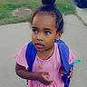 Bethlehem is registered to the contest to win money with this photo: child, toddler, girl, portrait, outdoor, sidewalk, grass, backpack, pink_dress, hair_bun, looking_away, standing, neighborhood, residential, trash_bin, blue_bin, daytime, pavement, necklace, street_photography
