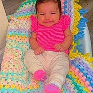 Rubi joined the competition — help win amazing prizes! baby, cheerful, child, colorful_blanket, cozy, crocheted_blanket, cute, floor, happy, indoor, infant, lying_down, pink_shirt, portrait, small_hands, smile, socks, soft_texture, striped_clothing, toddler