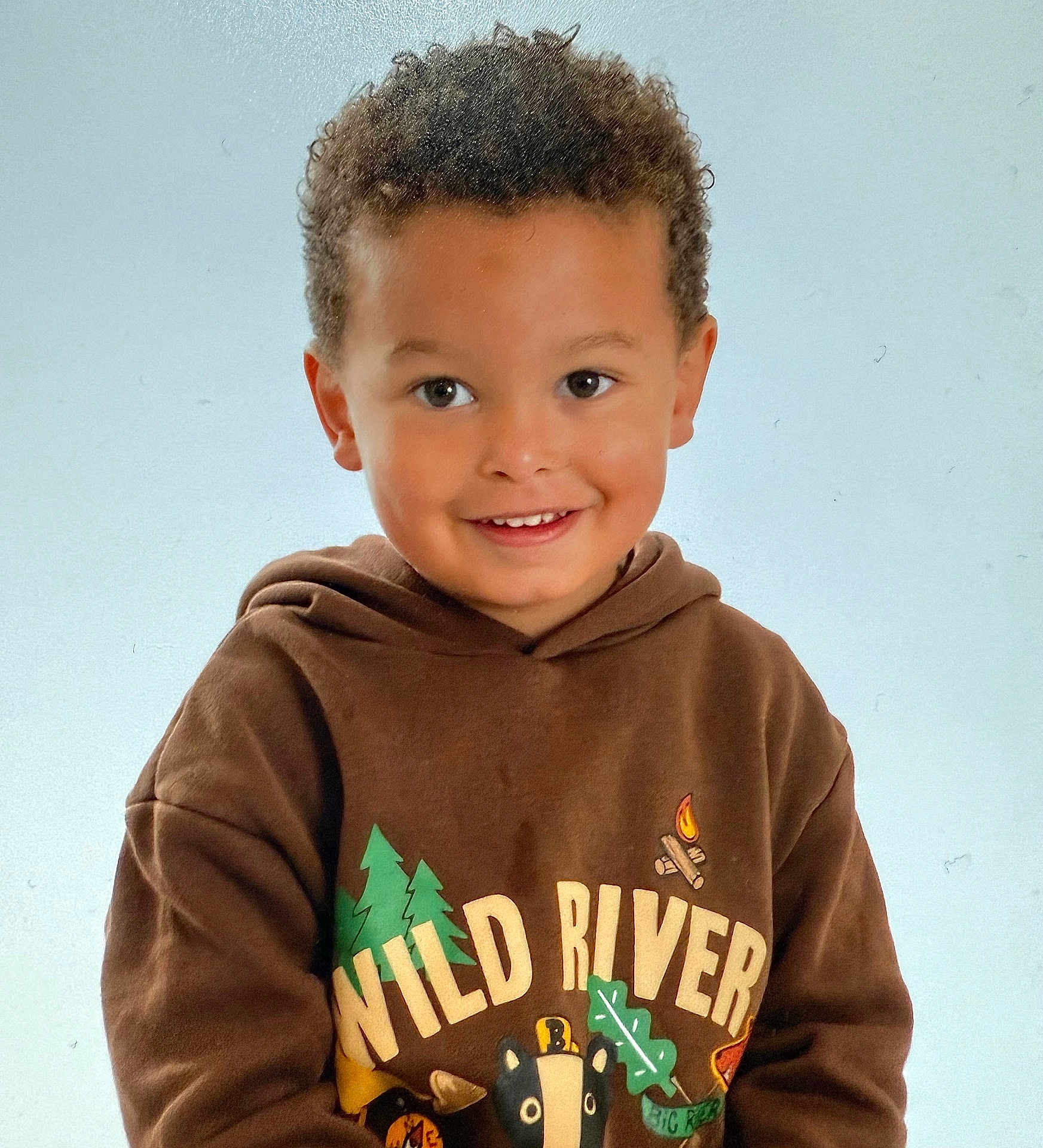 Dion joined the competition — help win amazing prizes! child, smiling, hoodie, brown_clothing, curly_hair, portrait, indoor, young_child, happy, face, casual_wear, person, cute, studio_lighting, childhood, sweatshirt, graphic_clothing, light_background, close_up, friendly