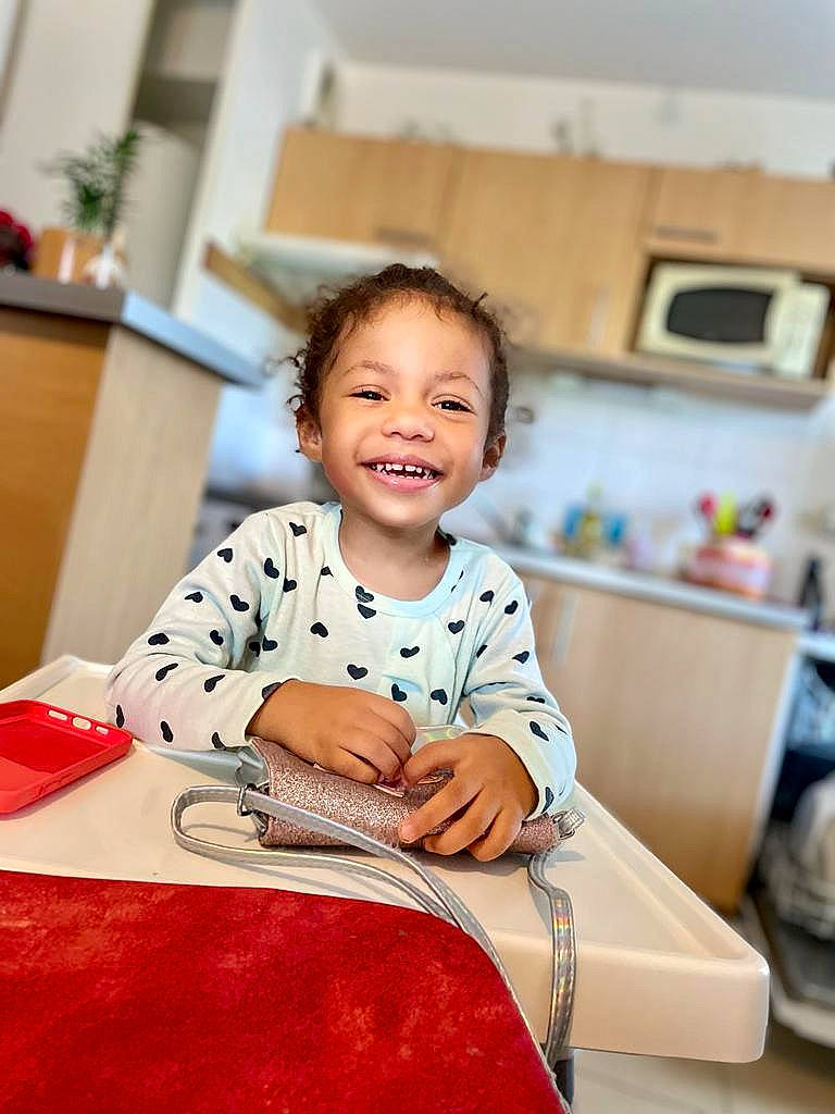 Inayah participe au concours pour gagner de l'argent avec cette photo : baby, baby_toddler_clothing, child, flooring, fun, happy, houseplant, joy, leisure, living_room, pattern, person, play, portrait_photography, room, sitting, sleeve, smile, t_shirt, toddler