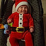 Elio participe au concours pour gagner de l'argent avec cette photo : baby, infant, santa_suit, christmas_hat, smile, car_seat, toy_elephant, red_outfit, holiday, festive, plush, buckle, belt, cozy, indoor, portrait, adorable, chubby_cheeks, cute, seat
