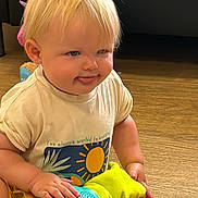 Jaxon is registered to the contest to win money with this photo: blonde_hair, child, colorful, cute, expression, face, hand, happy, indoor, light, person, playing, shirt, short_sleeves, sitting, smiling, toddler, toy, wooden_floor, young_child