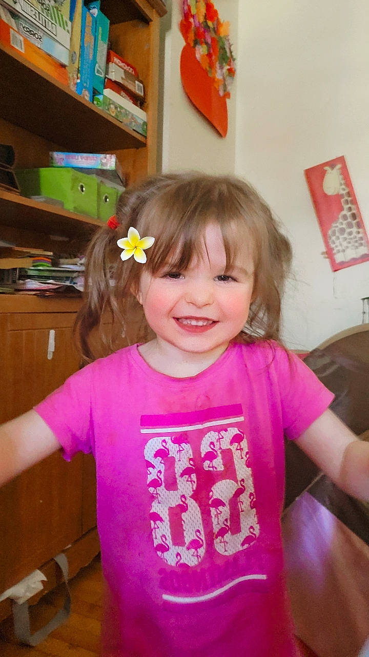 Sky is registered to the contest to win money with this photo: baby_toddler_clothing, bangs, chair, cheek, child, drawer, fun, happy, joy, magenta, party, person, picture_frame, play, room, shelf, sleeve, smile, t_shirt, thumb