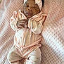 baby, sleeping, pink_outfit, headband, strawberry_pattern, blanket, soft_texture, infant, cute, peaceful, hands_clasped, cozy, newborn, portrait, indoors, child, clothing, headwear, resting, toddler