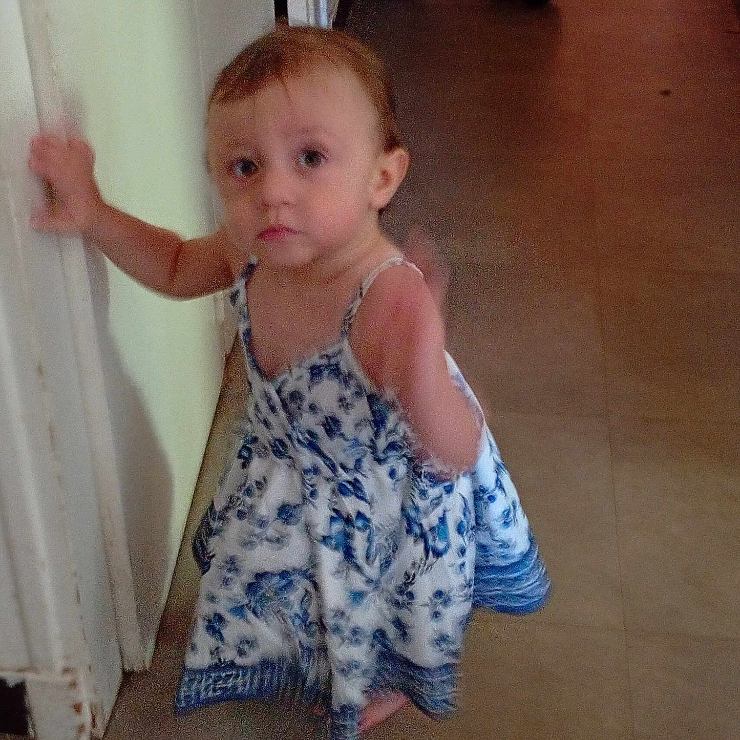 Elena participe au concours pour gagner de l'argent avec cette photo : barefoot, child, curious, dress, face, floor, floral_pattern, hand, home, indoor, light, looking, motion_blur, person, standing, toddler, toy, wall, wheels, young_child