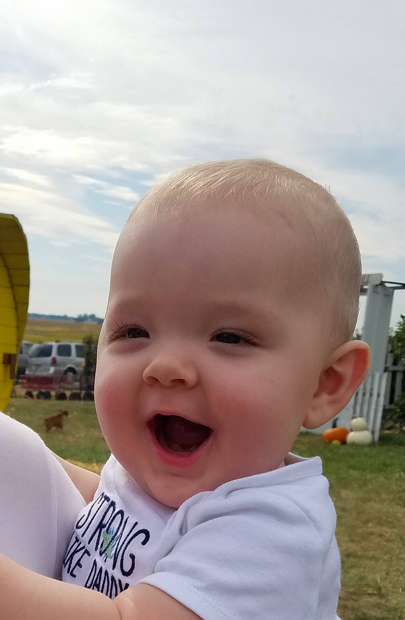 Layne is registered to the contest to win money with this photo: baby, cheek, child, chin, eye, face, facial_expression, forehead, fun, grass, head, lip, mouth, nose, person, skin, sky, smile, summer, toddler