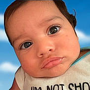 Psalm Graceson is registered to the contest to win money with this photo: baby, closeup, face, eyes, pout, expression, infant, child, skin, clothing, shirt, blue_sky, clouds, portrait, cute, young, person, head, humor, slogan