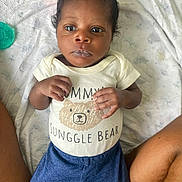 Rayquan is registered to the contest to win money with this photo: baby, infant, child, onesie, clothing, blanket, lying_down, hands, legs, person, face, cute, blue_pants, patterned_socks, indoor, soft_texture, newborn, portrait, baby_girl, baby_boy