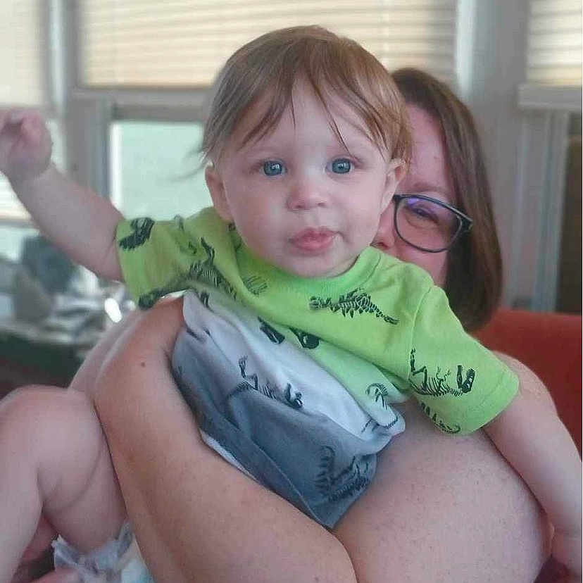 Tucker is registered to the contest to win money with this photo: accessories, baby, child, clothing, couch, cushion, diaper, face, female, furniture, girl, glasses, head, homedecor, indoors, person, photography, portrait, shorts, t_shirt