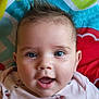 baby, infant, face, blue_eyes, expression, mouth_open, cherry_pattern, clothing, pink_shirt, colorful_blanket, pattern, cute, child, portrait, skin, hair, eyebrows, close_up, happy, lying_down