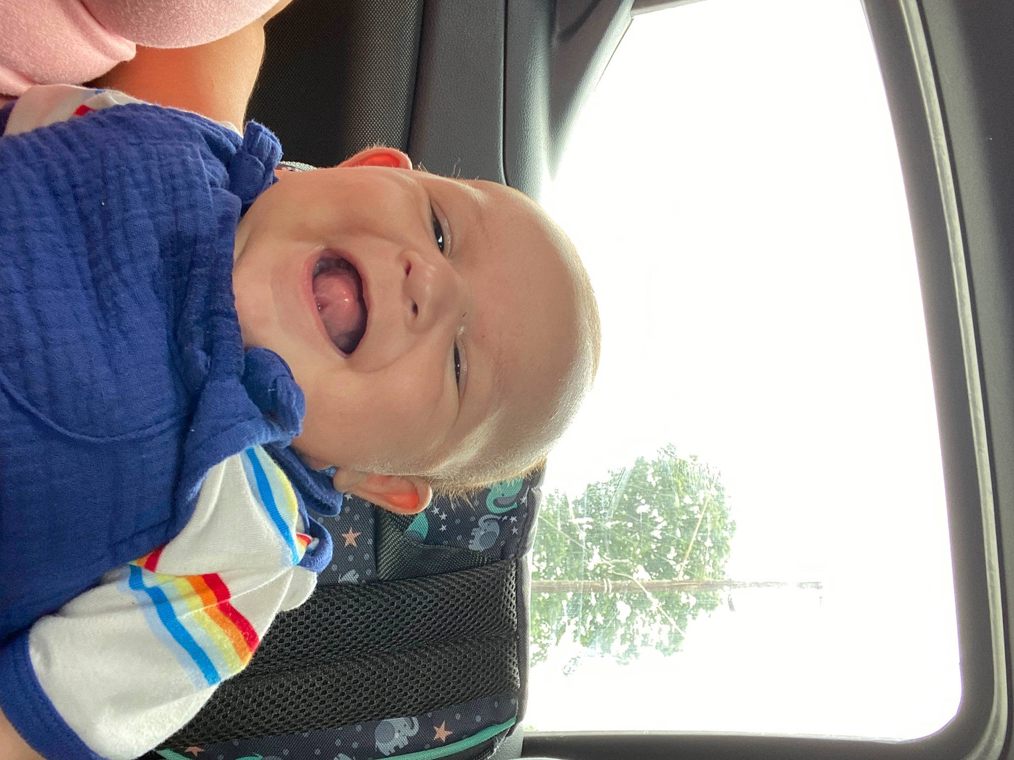 Kylan is registered to the contest to win money with this photo: automotive_exterior, automotive_mirror, automotive_window_part, baby, baby_products, baby_toddler_clothing, child, comfort, electric_blue, fun, happy, mammal, nose, person, rear_view_mirror, smile, toddler, tree, vehicle_door, window