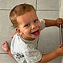 Noah a rejoint le concours — aidez-le/la à gagner de superbes lots ! toddler, child, smiling, happy, floor, tile, metal_bar, clothing, short_sleeves, barefoot, indoor, person, cute, baby, face, young_child, playful, looking_up, hands, crawling