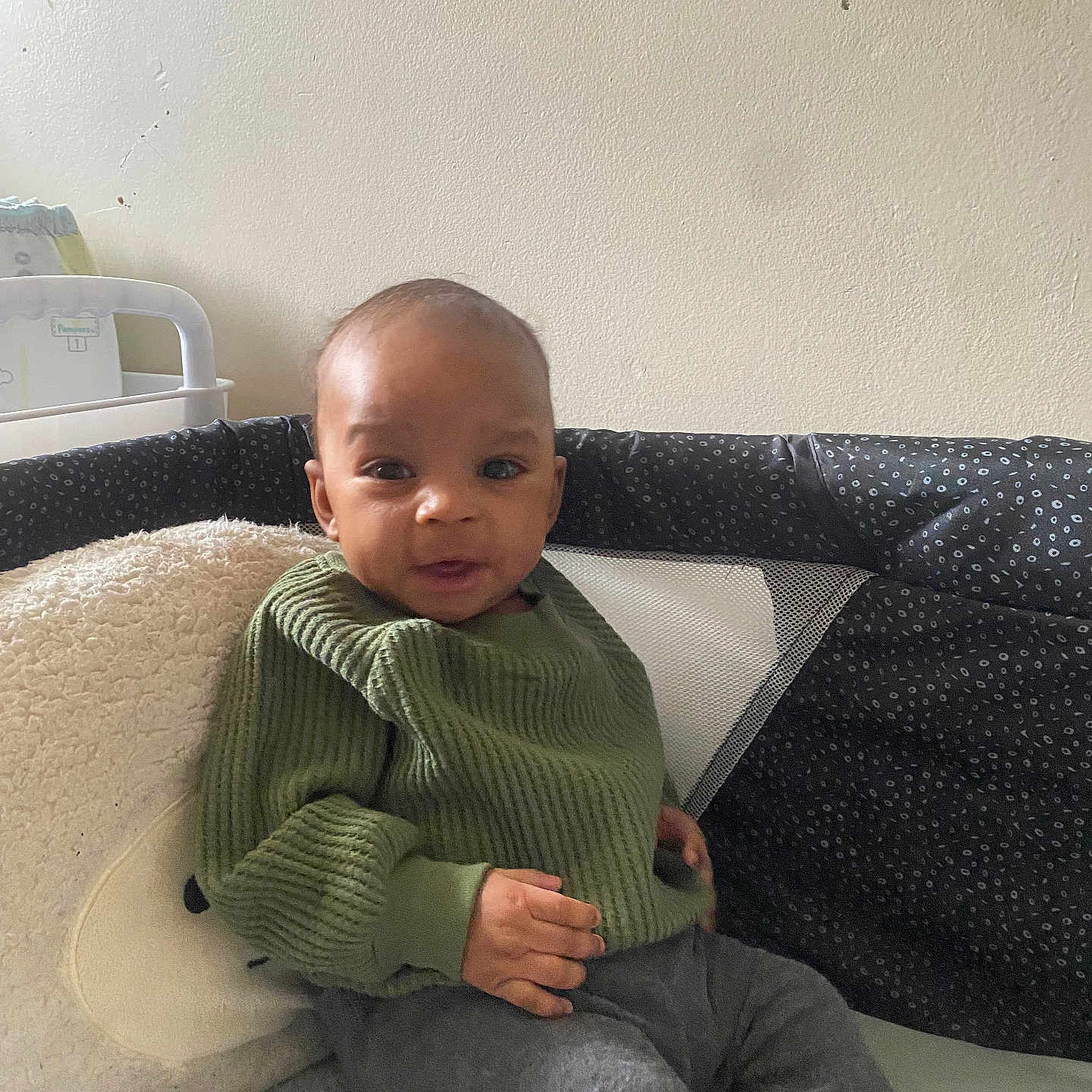 Jacobe joined the competition — help win amazing prizes! baby, casual_clothing, child, comfort, cozy, cushion, cute, face, gray_pants, green_sweater, home, indoor, infant, person, plush_pillow, portrait, relaxed, sitting, soft_texture, young_child