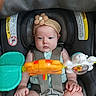 Trinity joined the competition — help win amazing prizes! baby, infant, car_seat, headband, flower, toy, colorful_toy, straps, safety, child, cute, serious_expression, hands, legs, indoors, seatbelt, plastic_toy, closeup, person, young_child