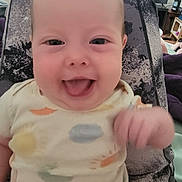 Trinity joined the competition — help win amazing prizes! baby, smile, tongue_out, infant, cushion, patterned_clothing, indoor, joyful, closeup, person, child, happy, seated, casual, head, skin, cheerful, cute, expression, relaxed