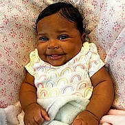 Raelynn joined the competition — help win amazing prizes! baby, infant, smiling, blanket, clothing, cute, face, child, happy, portrait, indoors, hand, skin, person, toddler, fingertip, sleeve, cozy, warm, pattern