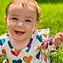 baby, child, smiling, face, blue_eyes, teeth, grass, outdoor, sunlight, happy, heart_pattern, clothing, cute, portrait, infant, nature, skin, head, person, daylight