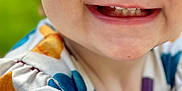 Oakley is registered to the contest to win money with this photo: toddler, child, smile, teeth, face, eyes, closeup, colorful_clothing, outdoor, green_background, happy, joyful, cute, infant, portrait, baby, playful, skin, young, person