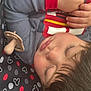 Josiah is registered to the contest to win money with this photo: child, sleeping, pacifier, grey_clothing, red_cuff, mickey_mouse_pattern, cushion, closeup, face, hair, hand, relaxation, indoor, soft_light, peaceful, baby, rest, cozy, infant, portrait