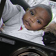 Tycia participe au concours pour gagner de l'argent avec cette photo : baby, child, camera, screen, digital_camera, portrait, face, zoom_lens, technology, indoor, closeup, vhs_effect, retro_style, video_recording, infant, young_child, electronic_device, photo_capture, nostalgic, grainy