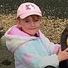 Aurora joined the competition — help win amazing prizes! child, cap, pink, jacket, outdoor, playground, tire_swing, smile, face, person, multicolored, young, holding, pebbles, casual_clothing, headwear, cute, happy, leisure, recreation