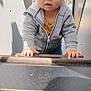 Tymaël participe au concours pour gagner de l'argent avec cette photo : child, toddler, playground, climbing, grey_hoodie, yellow_shirt, blue_eyes, outdoor, daylight, stairs, curious, baby, person, metal_structure, sky, clouds, hands, casual_clothing, young_child, focused