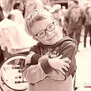 Loann participe au concours pour gagner de l'argent avec cette photo : child, boy, glasses, smile, hoodie, paw_patrol, arms_crossed, wheelchair, people, outdoor, crowd, sepia, portrait, happy, casual_clothing, young, glasses_frame, kid, background_blur, daytime
