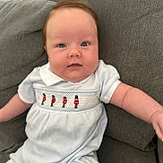 Arlo joined the competition — help win amazing prizes! baby, infant, child, blue_eyes, light_blue_outfit, embroidered_clothing, toy_soldiers, couch, gray_fabric, seated, cute, chubby_cheeks, indoor, portrait, smiling, short_hair, comfortable, relaxed, young_child, human
