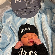 Ares joined the competition — help win amazing prizes! baby, newborn, sleeping, black_clothing, hat, blanket, blue_blanket, birth_announcement, sign, text, infant, person, cute, peaceful, soft_texture, indoors, portrait, resting, sleep, child