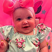 Sophia is registered to the contest to win money with this photo: accessories, baby, bodypart, bonnet, clothing, cushion, dress, face, finger, flower, furniture, hand, happy, hat, head, person, photography, plant, portrait, smile