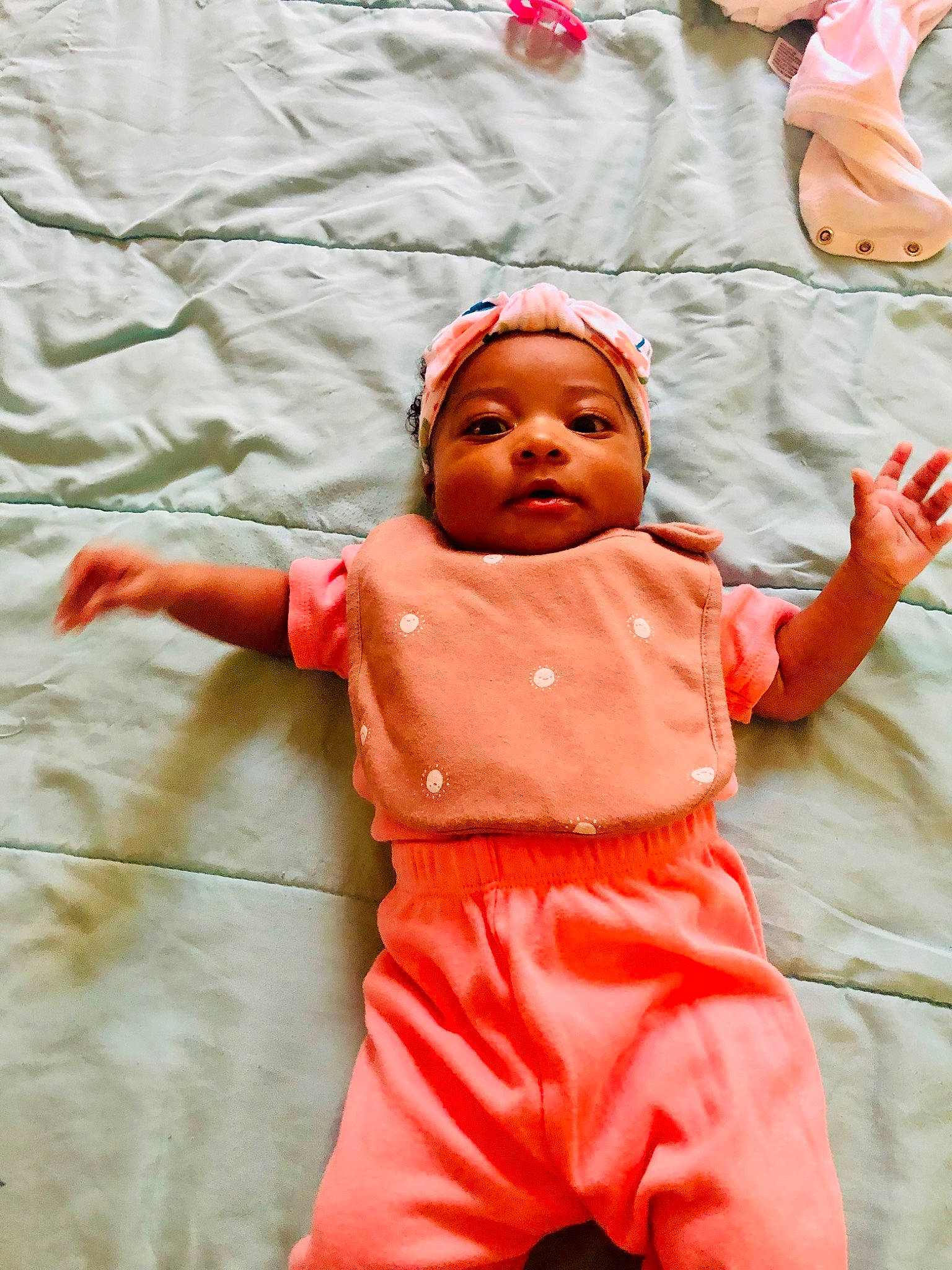 Angelica is registered to the contest to win money with this photo: baby_toddler_clothing, cheek, child, chin, facial_expression, finger, fun, gesture, hand, happy, headwear, human_body, joint, orange, person, pink, play, sitting, sleeve, t_shirt