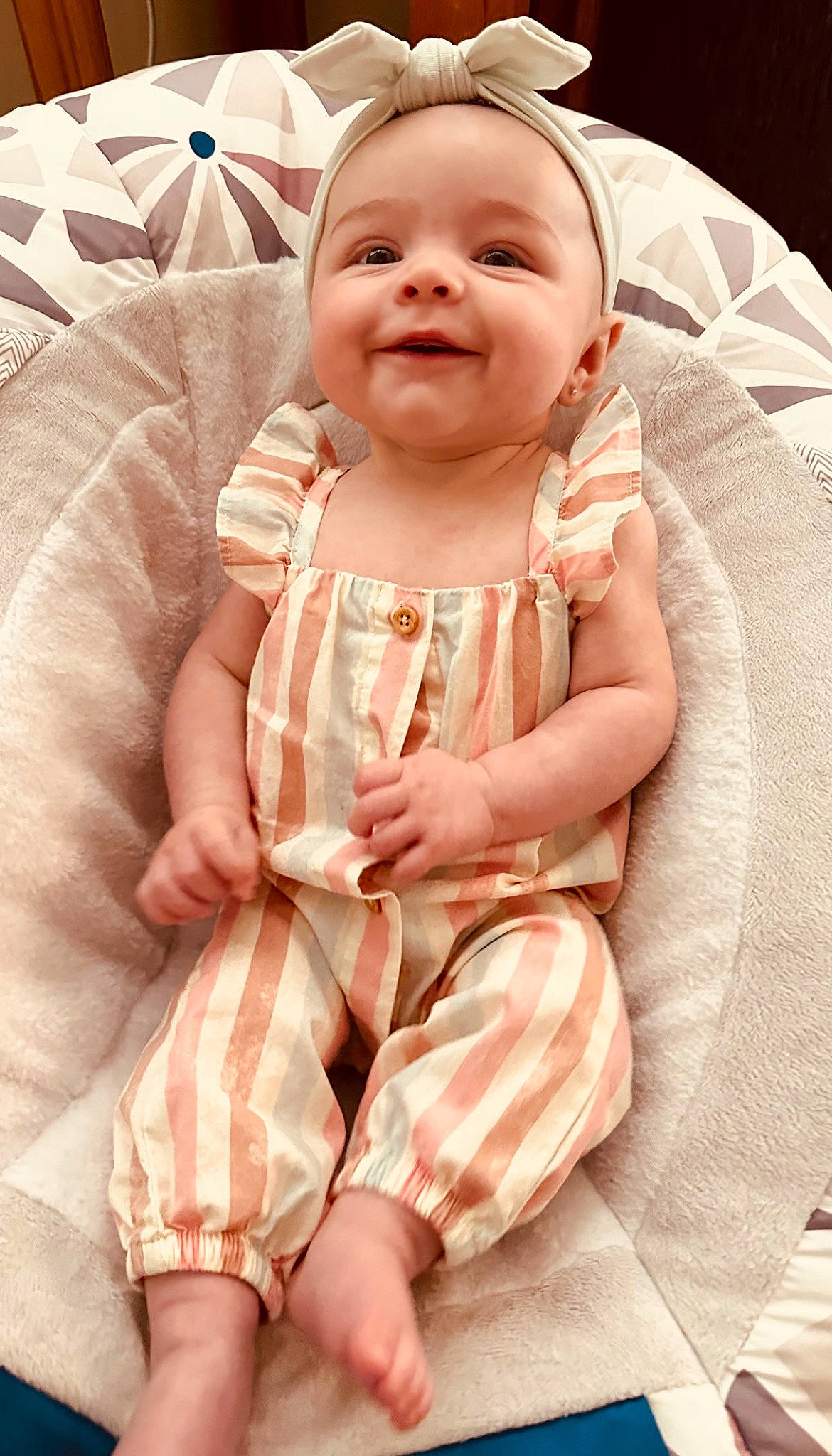 Remington is registered to the contest to win money with this photo: baby, baby_safety, baby_toddler_clothing, cheek, child, comfort, dress, finger, happy, human_body, joy, linens, lip, pattern, peach, person, pink, skin, sleeve, smile