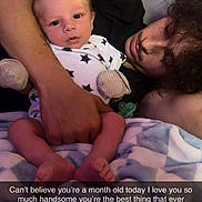 Kaiden is registered to the contest to win money with this photo: baby, infant, adult, person, bed, blanket, pillow, pajamas, stars, holding, lying_down, indoor, parent, child, face, hand, love, family, cuddling, sleepwear