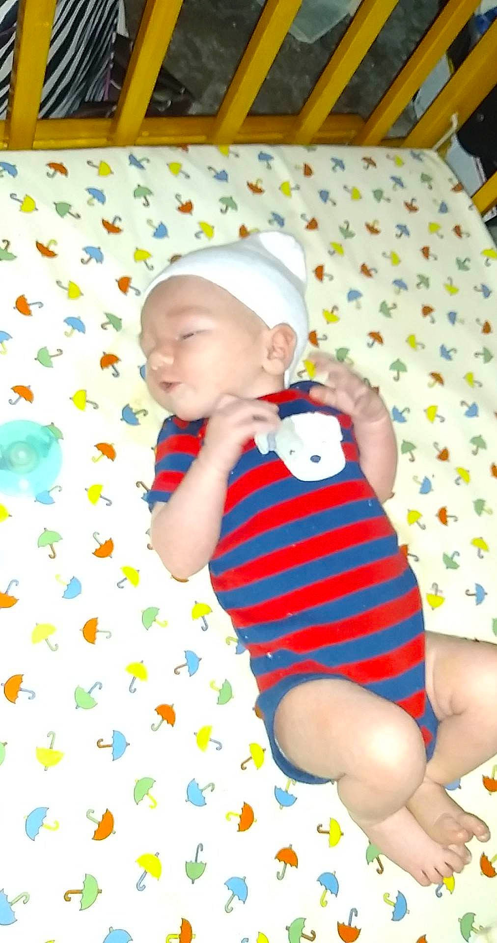 Jasper is registered to the contest to win money with this photo: baby, baby_products, baby_toddler_clothing, cap, child, comfort, fun, happy, headwear, human_leg, knee, linens, pattern, person, product, skin, sleeve, sock, t_shirt, textile