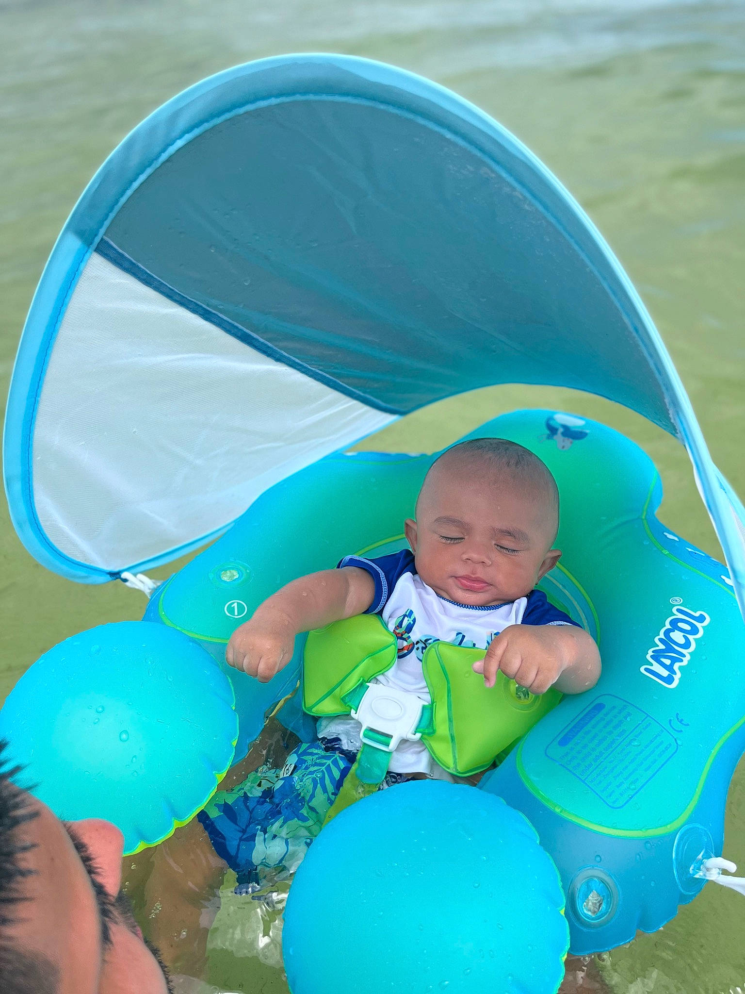 Casey is registered to the contest to win money with this photo: aqua, azure, baby, baby_products, baby_toddler_clothing, balloon, blue, child, electric_blue, fun, grass, green, happy, inflatable, leisure, person, recreation, sitting, toddler, water