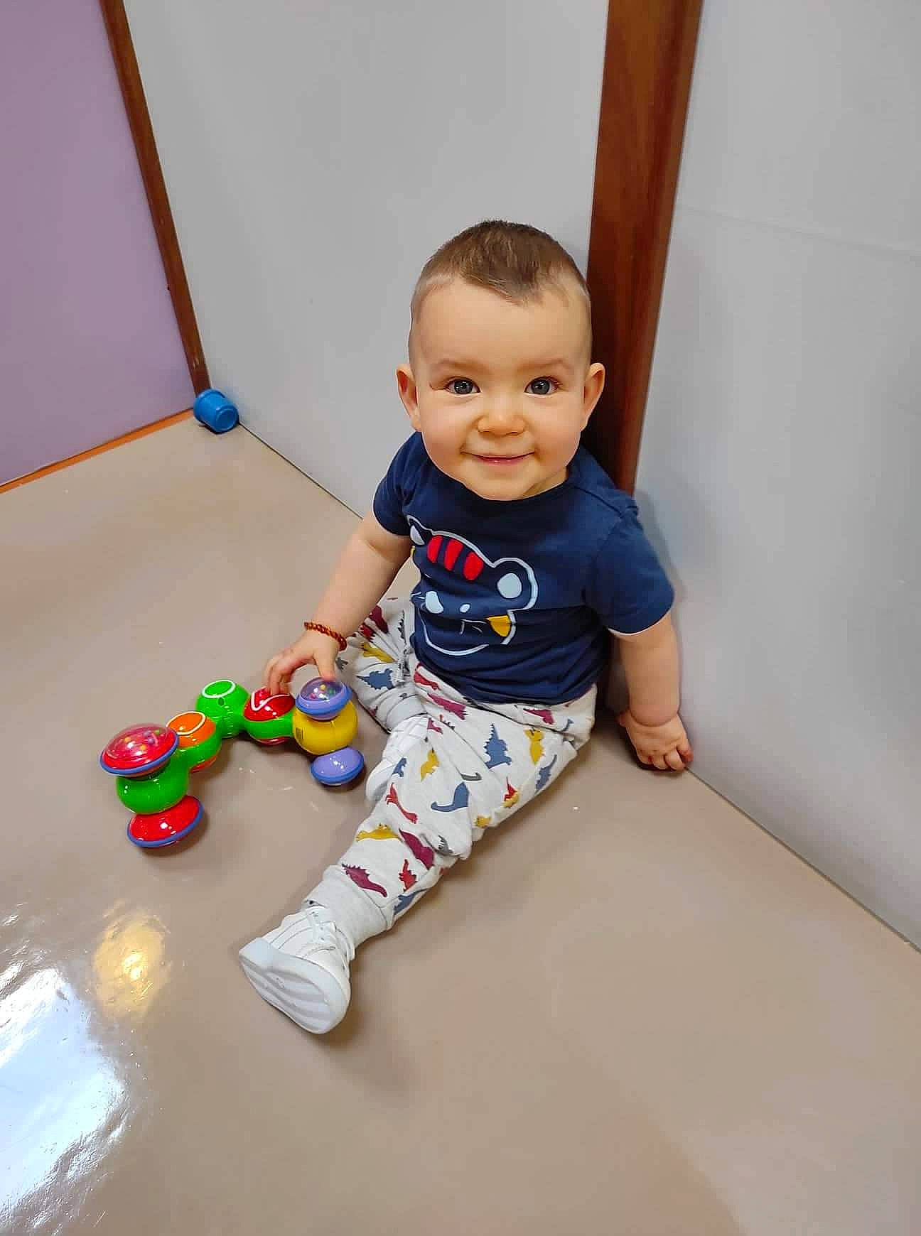 Nino a rejoint le concours — aidez-le/la à gagner de superbes lots ! baby, baby_toddler_clothing, balance, child, cleanliness, composite_material, elbow, floor, flooring, fun, happy, joy, knee, person, play, room, sitting, sleeve, smile, t_shirt